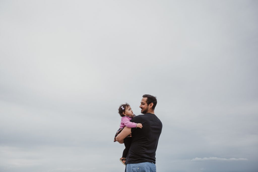 Father holding first daughter during her birthday celebration in Crescent Beach White Rock Surrey BC Canada