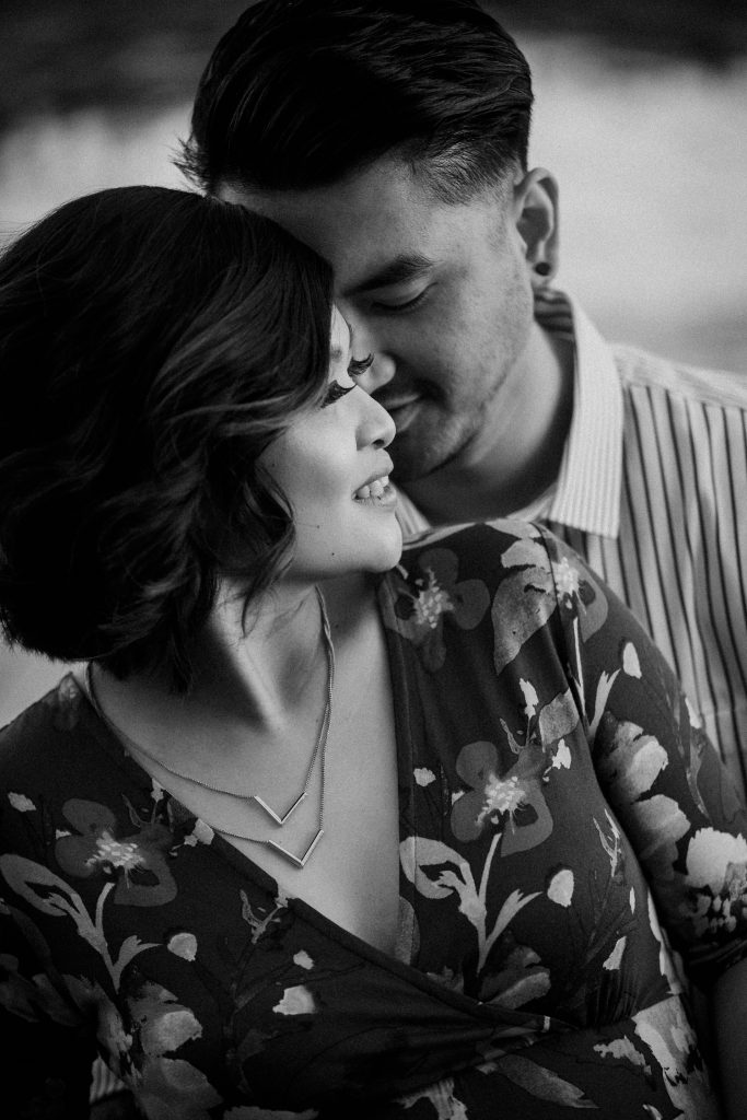 Man and his pregnant wife having a nice time at a park. A beautiful picture captured by toronto wedding photographer.