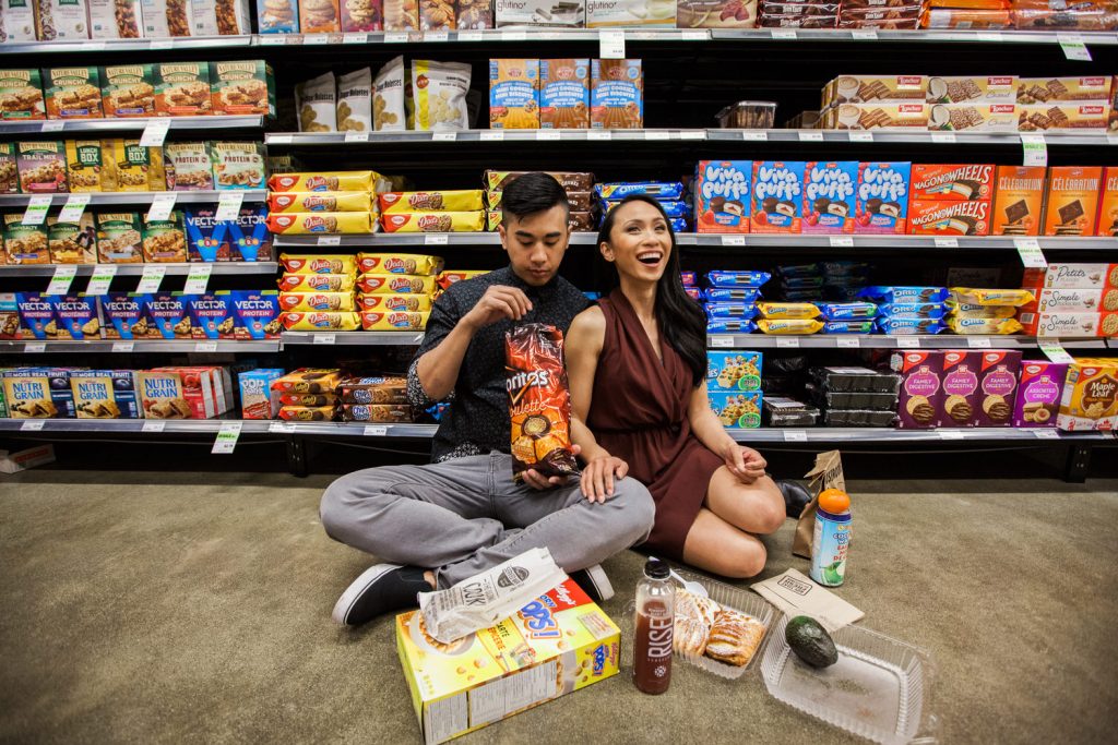 Unique engagement session in a grocery store where couple is seen eating their favourite snacks