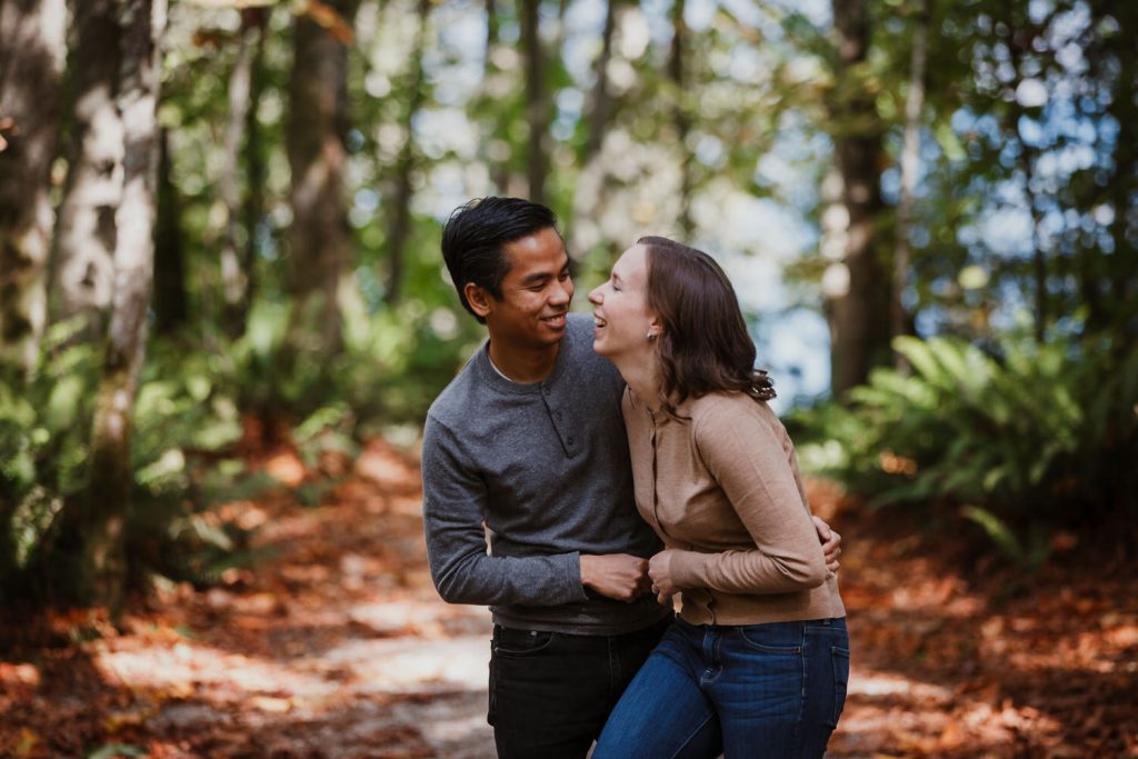 Couple tickling each other during their Pacific Spirit Engagement Session in the Fall