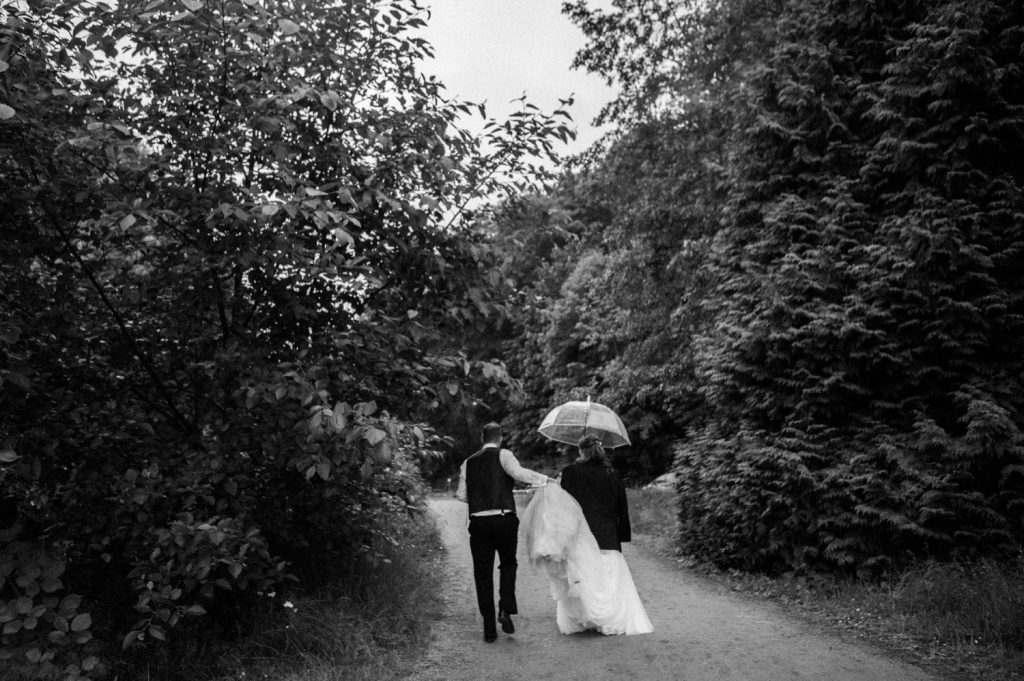 Black and white photo of the bride and groom walking to the reception in spanish banks