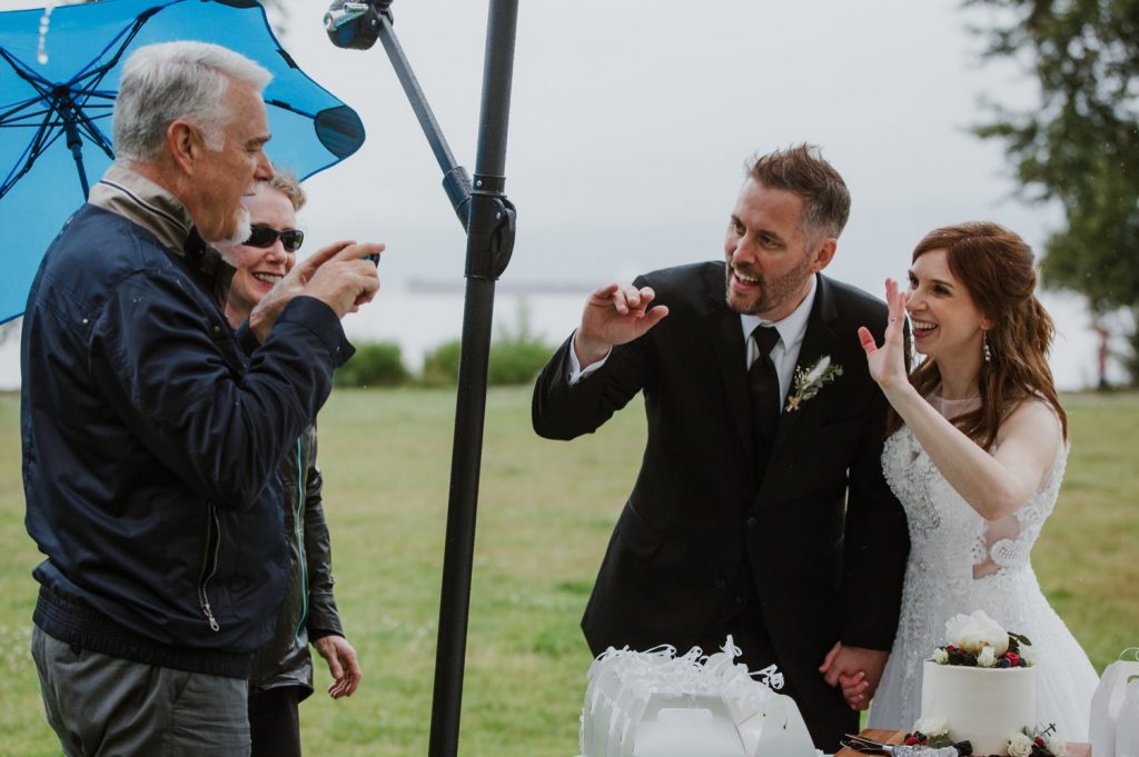 Bride and groom waving to guests on the phone