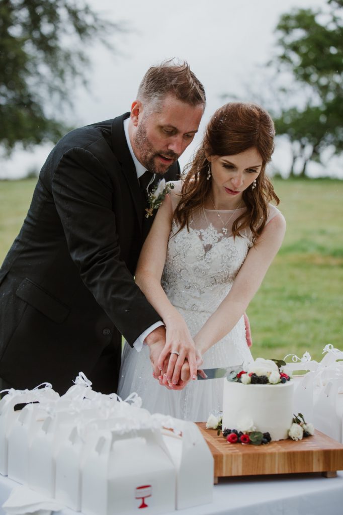 Bride and groom cutting the cake outdoors in spanish banks