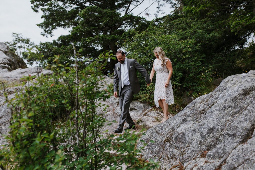 Candid photograph of bride and groom walking in whytecliff park