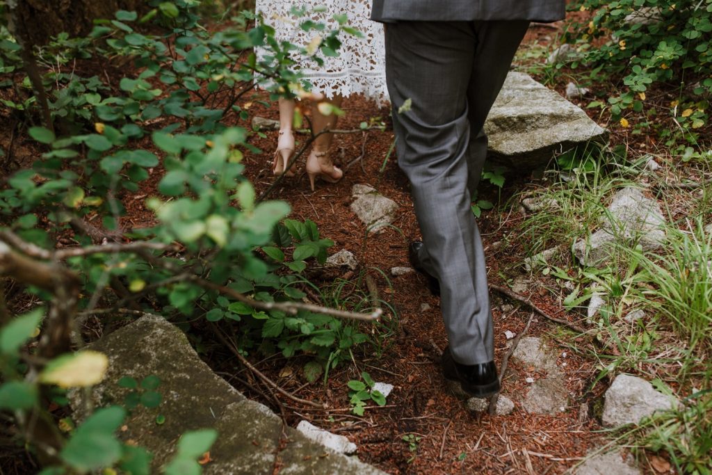 Candid photograph of the bride and groom's shoes while they are walking